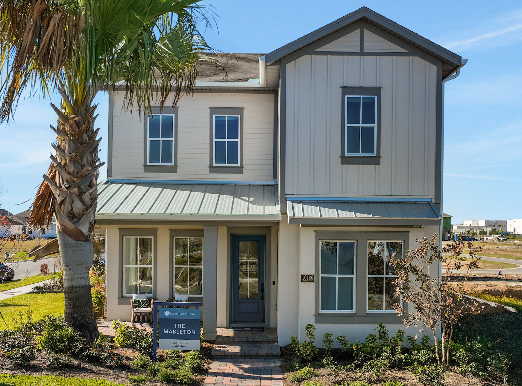 Photo of Mableton model home elevation by Dream Finders Homes in Laureate Park in Lake Nona Orlando, Florida. Light brown house with a blue sign in the front.